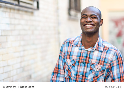 Portrait of black man very happy, smiling in urban background